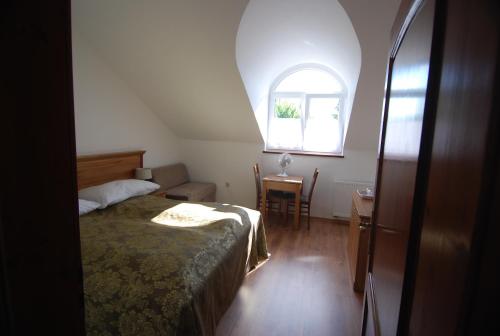 a bedroom with a bed and a window and a table at Ivanek guest house in Zvíkovské Podhradí