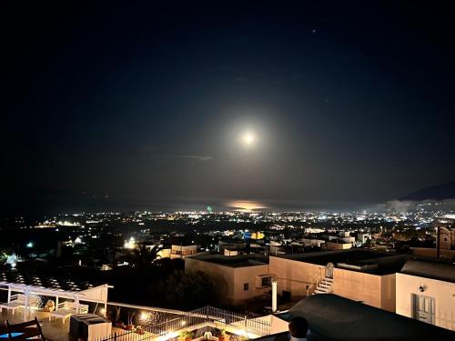 a view of a city at night with the moon at Firaxenia rooms in Fira