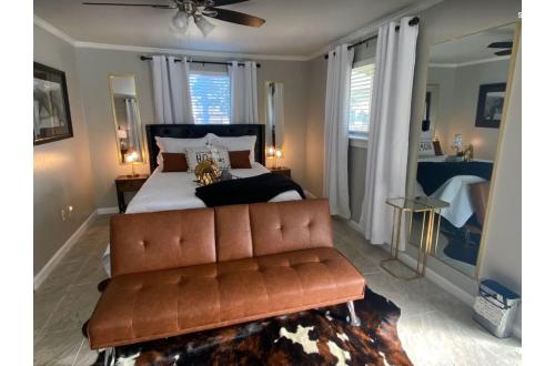 a bedroom with a couch and a bed with windows at Stunning Cozy Downtown Guesthouse in San Antonio