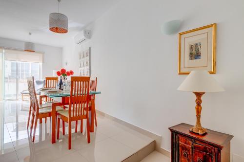 a dining room with a table and chairs and a lamp at Prime Location Apartment with Side Seaviews in Sliema