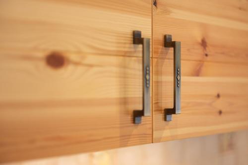 a wooden drawer with two handles on a wooden wall at PRIVILLAGE Stare - Villa & Chalet in Bohinj
