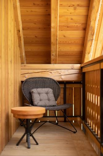 a chair and a table in a room with wooden walls at PRIVILLAGE Stare - Villa & Chalet in Bohinj