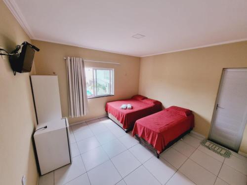 Zimmer mit 2 Betten und einem Kühlschrank in der Unterkunft Pousada Espaco Verde in Itarema