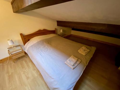une chambre avec un lit avec deux serviettes dessus dans l'établissement Appartement cosy au pied du MtBlanc, à Chamonix-Mont-Blanc