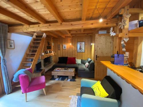 - un salon avec un canapé et des escaliers dans une maison dans l'établissement Appartement cosy au pied du MtBlanc, à Chamonix-Mont-Blanc
