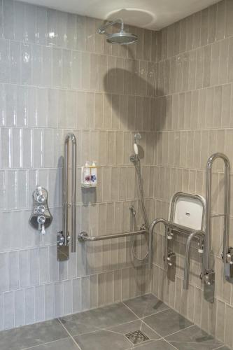a shower in a bathroom with a tile wall at Oyster House in The Mumbles