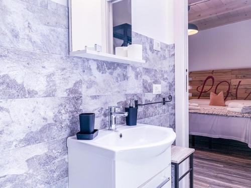 Un baño con un lavabo blanco en una habitación. en BB 26 Olbia, en Olbia