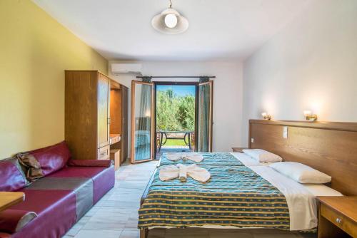 una camera d'albergo con un letto e un divano di Mirage Arillas Studio Type C16 a Arillas