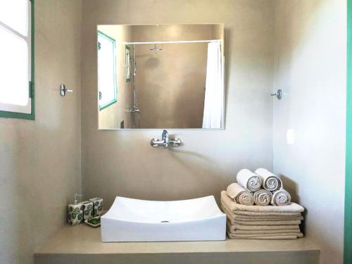 a bathroom with a sink and a mirror and towels at Asteri Apartments in Alonnisos Old Town