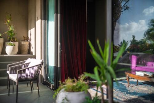 a balcony with chairs and plants on a porch at Casa Malca in Tulum
