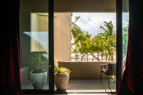 a room with a view of a balcony with a plant at Casa Malca in Tulum