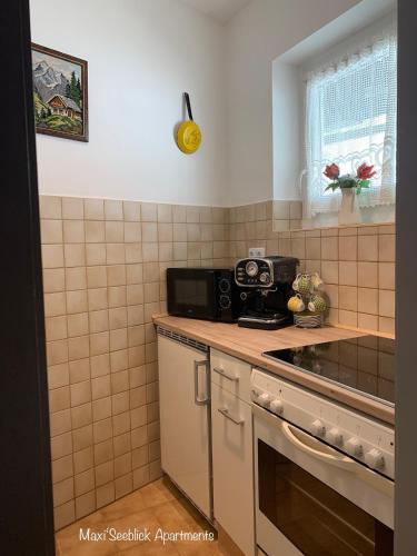 a kitchen with a stove and a microwave at Maxi'Seeblick Apartments in Seeboden