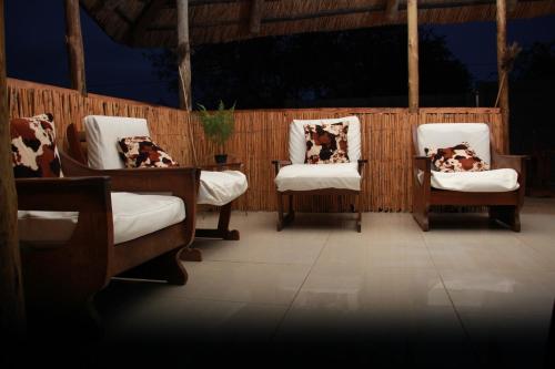 a group of three chairs with pillows on them at Siyaya’s Guest Palace in Jozini