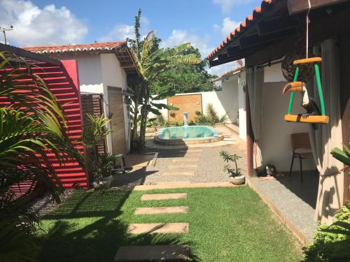 a garden with a swimming pool in a house at AYRE GOSTOSO POUSADA in São Miguel do Gostoso