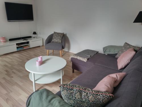 a living room with a couch and a table at Ferielejlighed Skovby ved Bogense in Bogense