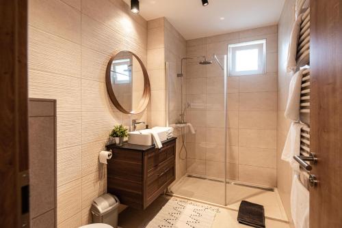 a bathroom with a shower and a sink and a mirror at OAK Residents Siófok in Siófok