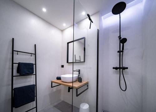 a white bathroom with a sink and a shower at Novouređeni apartman Marko in Mundanije