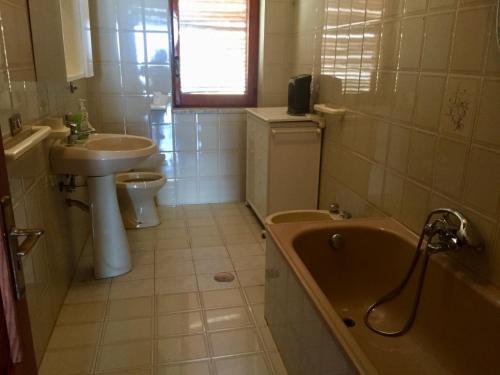 a bathroom with a sink and a tub and a toilet at La Casa di Zorbas in Cariati