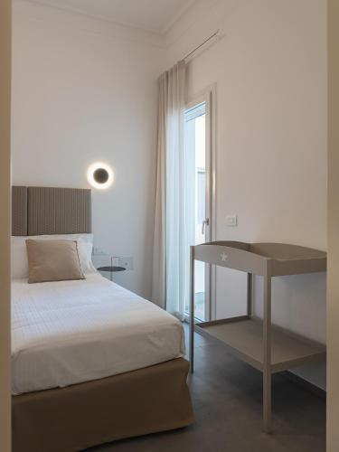 a bedroom with a bed and a desk and a window at Living u HomeSuites in Lecce