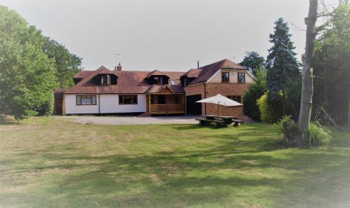a house with a picnic table in a yard at Mulberry Cottage near Goodwood in Chichester