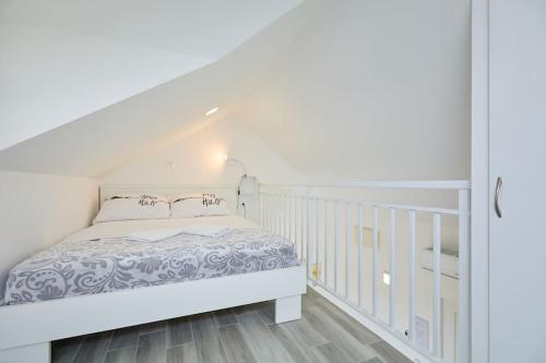a white bedroom with a bed and a staircase at Dora&Paulo sweet countryside cottage in Babino Polje