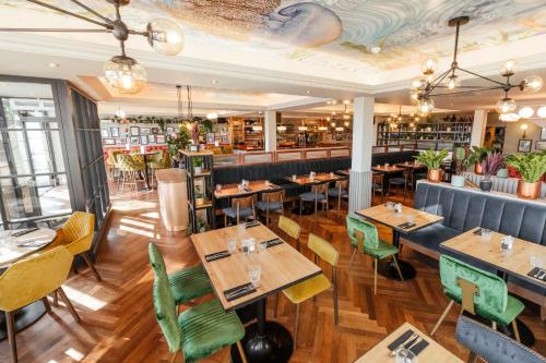 a restaurant with wooden tables and chairs and a bar at Oyster House in The Mumbles