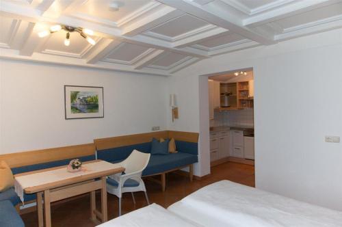 Zimmer mit einem blauen Sofa und einem Tisch in der Unterkunft Haus Angela in Sankt Jakob in Defereggen
