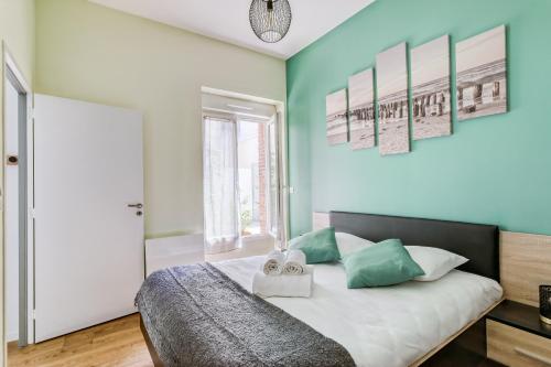 een slaapkamer met een bed met groene muren bij MOANA - Petit cocon situé quartier République in Nantes