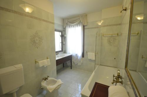 a bathroom with a tub and a sink and a shower at Hotel Villa Luppis in Pasiano di Pordenone