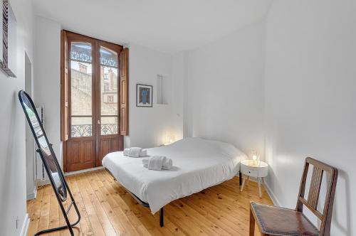 - une chambre blanche avec un lit et une fenêtre dans l'établissement LE MERCIER - Grand T4 de 100m2 en plein coeur de Toulouse, à Toulouse