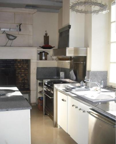 une cuisine avec une cuisinière et un évier dans l'établissement Maison Spacieuse & Piscine, à Saint-Bonnet-sur-Gironde