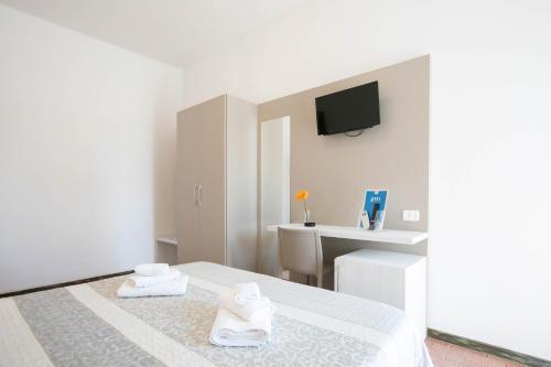 ein weißes Zimmer mit einem Bett und 2 Handtüchern in der Unterkunft Hotel Mara in Rimini