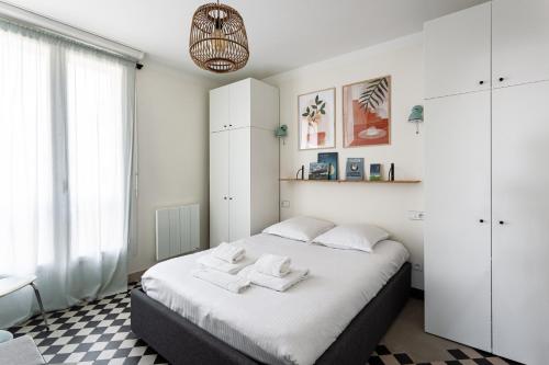 Un dormitorio blanco con una cama con toallas. en TERRASSE FADOLI - Grande terrasse avec vue mer et cathédrale, en Marsella