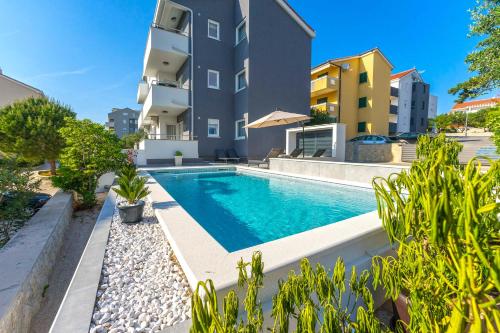 an image of a swimming pool in front of a building at Summer Breeze Pool Apartments in Novalja