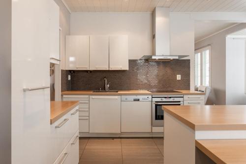 a white kitchen with white cabinets and a sink at The Grey House in Kokkola