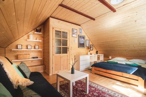 Blockhausschlafzimmer mit einem Bett und einem Tisch in der Unterkunft Jarzębinowa - Dom do wynajęcia na Podlasiu in Łuka