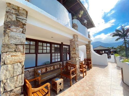a patio with chairs and a stone wall at HOTELARE Hotel Brunello in Paraty