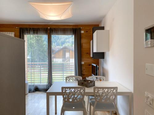 a dining room with a table and chairs and a window at Great Escapes in Ponte di Legno