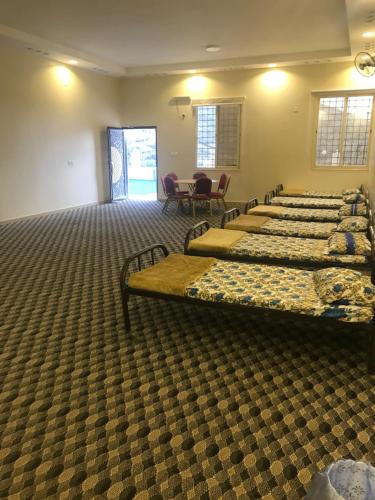 a row of beds in a room with chairs at استراحة الذروة in Abha