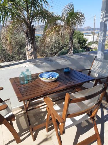 Villa Sofi in Saint George Antiparos (pool&sea) في أنديباروس: طاولة وكراسي خشبية على الفناء