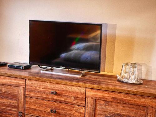 a flat screen tv sitting on top of a wooden dresser at Penzión Hron - Beňuš in Beňuš