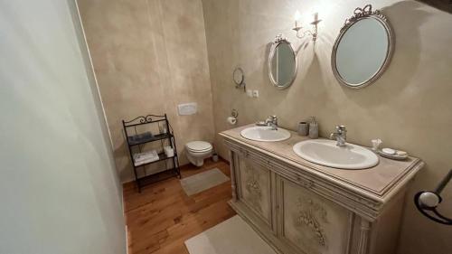 a bathroom with two sinks and a mirror at TENDANCE CAMPAGNE Chambre d'hôtes in Marillac