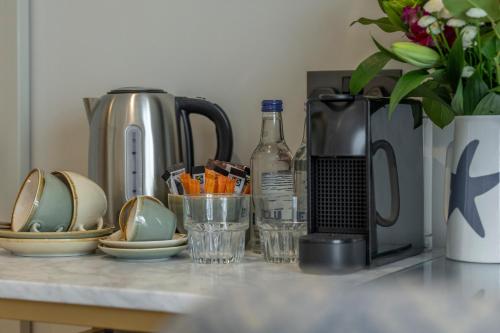a counter top with a coffee maker and plates and cups at Oyster House in The Mumbles