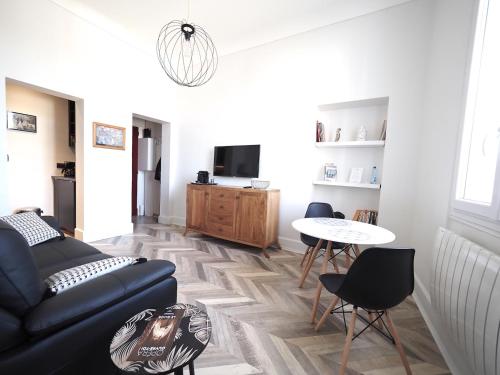 a living room with a couch and a table at Superbe appartement indépendant en centre ville in Vichy