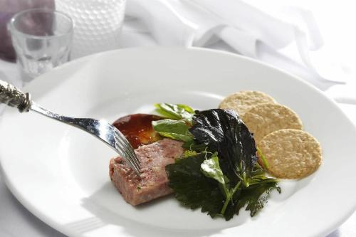 a plate of food with meat and greens on a table at Buchanan Arms Hotel & Leisure, Sure Hotel Collection in Drymen