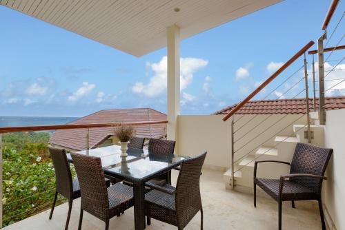 a patio with a table and chairs and the ocean at Villa Baan Saitara in Lamai