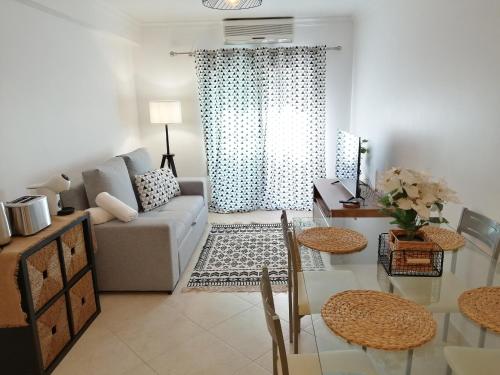 a living room with a couch and a table at Apartamento de 2 Quartos no Centro de Monte Gordo in Monte Gordo