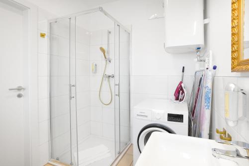 a shower in a bathroom with a washing machine at CT-GOLD Apartments - Villach Malina - nahe Atrio und Therme in Villach