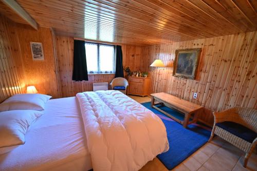 a bedroom with a large bed in a wooden room at River View in Rendeux