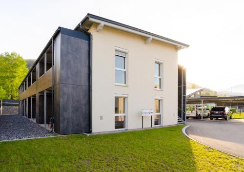 a large white building with a black facade at CT-GOLD Apartments - Villach Malina - nahe Atrio und Therme in Villach